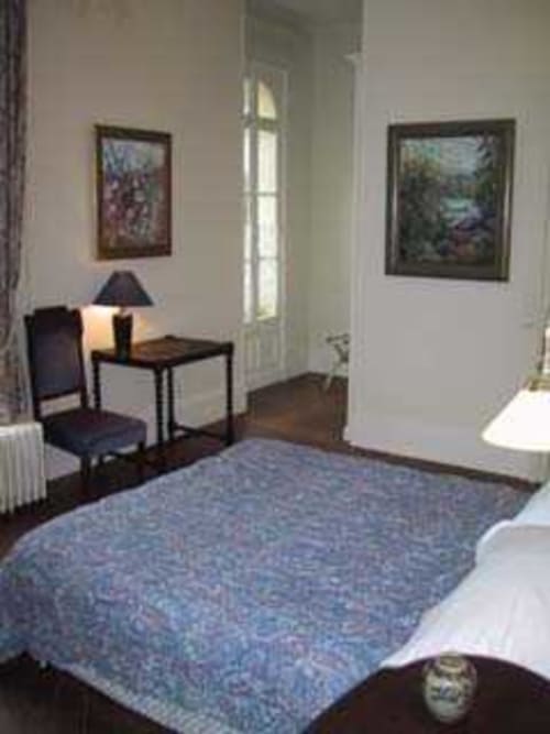 Chambre Iris au Chalet Du Bel Event B&B à La Chapelle-sur-Dun avec lit bleu, bureau, chaise et vue sur le jardin