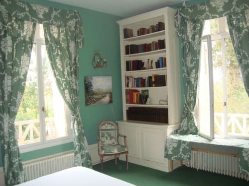 Chambre Verte au Chalet Du Bel Event avec murs turquoise, bibliothèque blanche, rideaux à motifs et vue sur le jardin