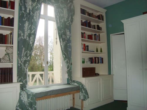 Chambre verte et blanche avec bibliothèques, coin lecture au fenêtre et vue sur le jardin du Chalet Du Bel Event