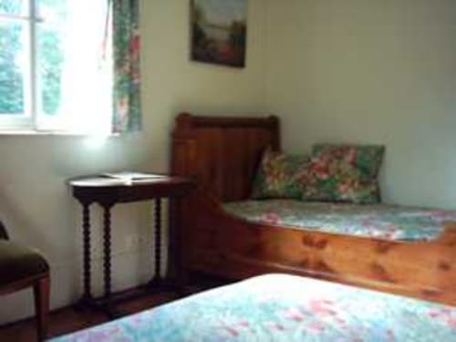 Chambre Tulipe au Chalet Du Bel Event avec vue jardin, lit en bois, parure florale, bureau et fenêtre à La Chapelle-sur-Dun