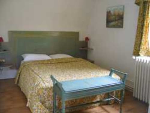 Chambre du Chalet Du Bel Event avec lit double, tête de lit verte et vue sur le jardin à La Chapelle-sur-Dun