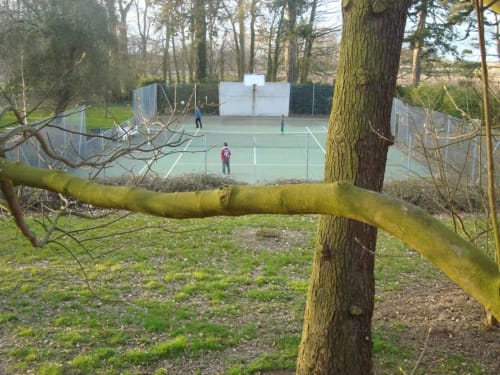 Tennis courts surrounded by trees at Chalet Du Bel Event in La Chapelle-sur-Dun, France