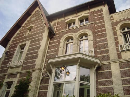Historic brick facade of Chalet Du Bel Event, a charming French B&B in La Chapelle-sur-Dun with arched windows