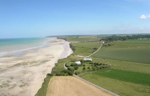 Aerial view of Chalet Du Bel Event beachfront property in La Chapelle-sur-Dun, France with coastal sand and green farmland.