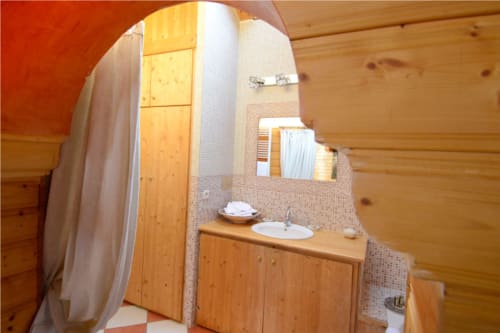 Salle de bain style mauresque à l'Auberge Nemoz avec meuble vasque en bois, lavabo rond et murs carrelés
