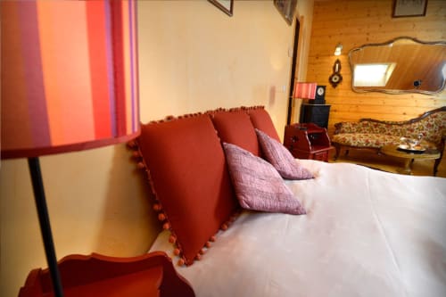 Chambre Méridien à l'Auberge Nemoz avec lit blanc, coussins rouges, lampe, mobilier en bois vue montagnes au Haut-Bréda