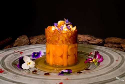Elegant orange cocktail with edible flowers at Chalet Du Bel Event, La Chapelle-sur-Dun, served on decorative plate