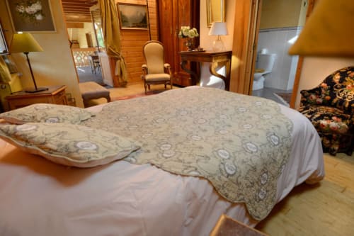 Chambre élégante à l'Auberge Nemoz avec lit queen, mobilier en bois et salon au Haut-Bréda
