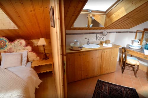 Levant room at Auberge Nemoz with wooden beams, bed, sink, and mountain views in Le Haut-Bréda