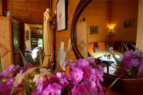Levant room at Auberge Nemoz with warm wood interior, purple flowers, mountain views, and traditional French alpine décor