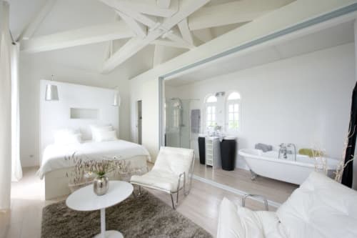 Suite de luxe au Château de Baylac avec baignoire attenante, poutres blanches, vue montagne et équipements modernes