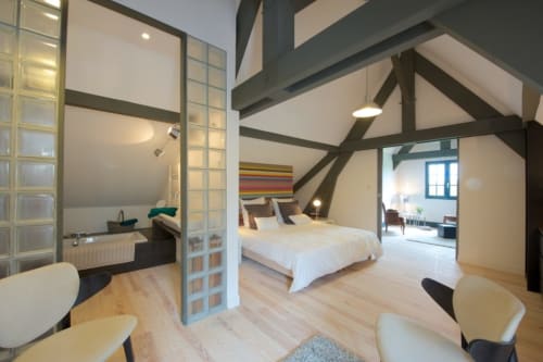 Suite Vivaldi au Château de Baylac : chambre spacieuse avec poutres apparentes, équipements modernes et vue montagne