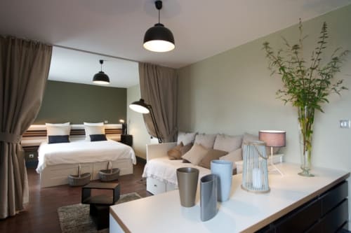 Château de Baylac, chambre familiale Racine avec lit, canapé, vue jardin et équipements modernes à Bugnein
