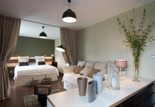 Chambre d'hôte moderne au Château de Baylac à Bugneain, avec lit, coin salon et plantes vertes