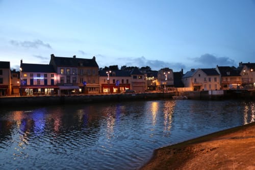 Vue waterfront de l'hôtel Les Filles du Bord de Mer au crépuscule à Port-en-Bessin-Huppain, France