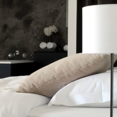 Luxe bed met kussens in hotel Moulin Renaudiots in Autun, met tuinuitzicht en moderne zwarte accentmuur