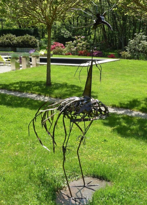 Metalen kraanbeeldhouwwerk in verzorgde tuin van Hotel Moulin Renaudiots, Autun Frankrijk