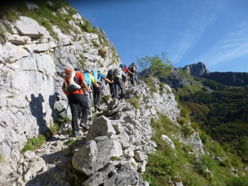 Groupe de randonneurs empruntant un sentier rocheux de montagne près du Château de Baylac à Bugnein, France