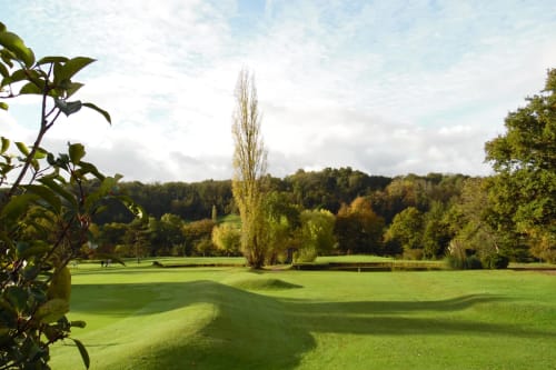Parcours de golf pittoresque du Château de Baylac à Bugnein avec greens entretenus, peuplier et forêt en arrière-plan