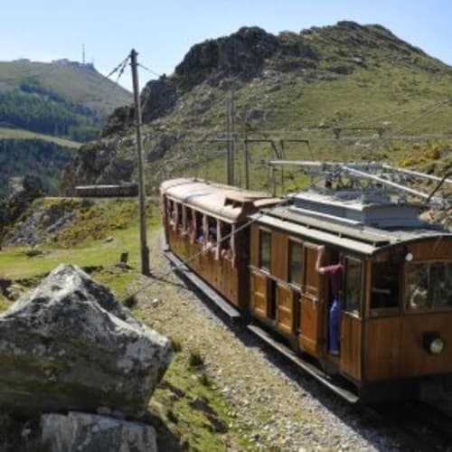 Train à crémaillère en montagne près du Château de Baylac à Bugneïn, Alpes françaises avec pentes verdoyantes