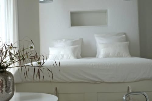 Chambre moderne au Château de Baylac avec literie blanche, oreillers et décoration épurée dans la suite Perce Neige