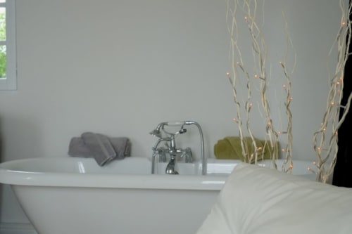 Baignoire luxueuse au Château de Baylac avec branches décoratives et serviettes dans la chambre Perce Neige, Bugnein
