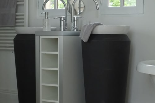 Salle de bains élégante avec deux vasques sur piédestal, robinetterie chromée et meuble noir à l'Hôtel Boutique Château de Baylac à Bugnein