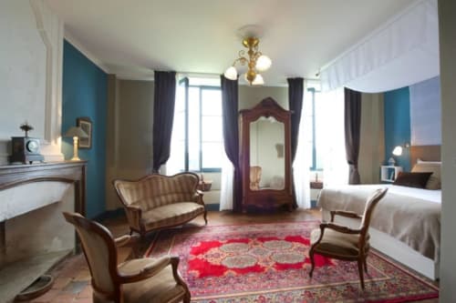Suite Lapis Lazuli du Château de Baylac avec lits jumeaux, cheminée et murs d'accent bleu-vert