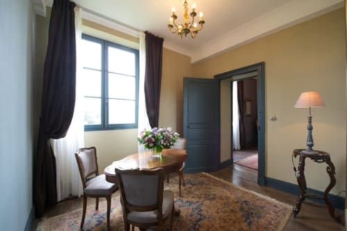 Suite Lapis Lazuli au Château de Baylac avec salon élégant, cheminée et vue sur les montagnes