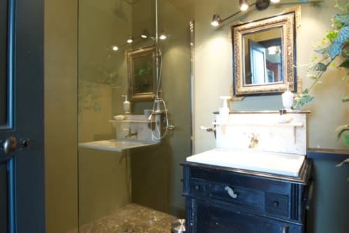 Salle de bains moderne de la Suite Lapis Lazuli au Château de Baylac avec meuble vasque bleu marine, miroir encadré et douche à l'italienne