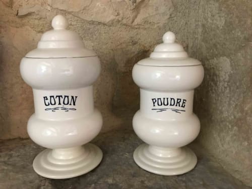 Two vintage white ceramic apothecary jars labeled 'Coton' and 'Poudre' at Manoir De Rieuzal B&B in Loubressac.