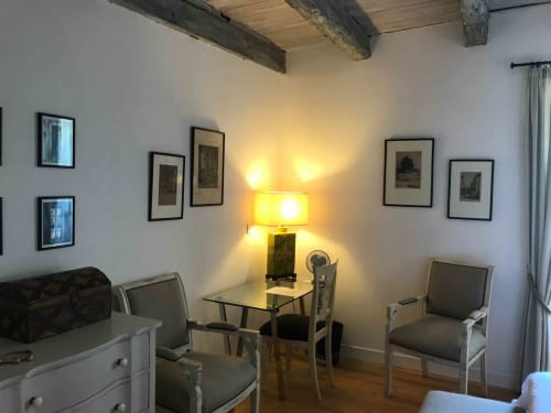 Verveine room at Manoir De Rieuzal featuring shared sitting area with desk lamp, framed artwork, wooden beams, and