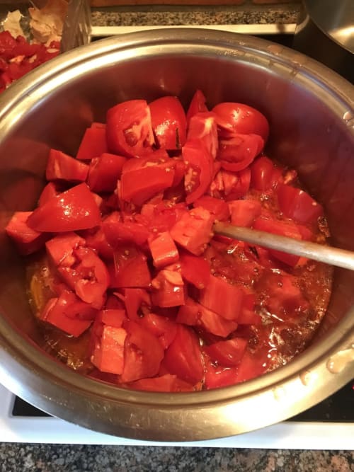 Chopped red peppers cooking in broth at Manoir De Rieuzal, a French bed and breakfast in Loubressac