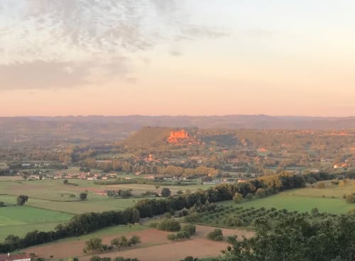 Loubressac village and castle at sunset with rolling French countryside fields and autumn foliage