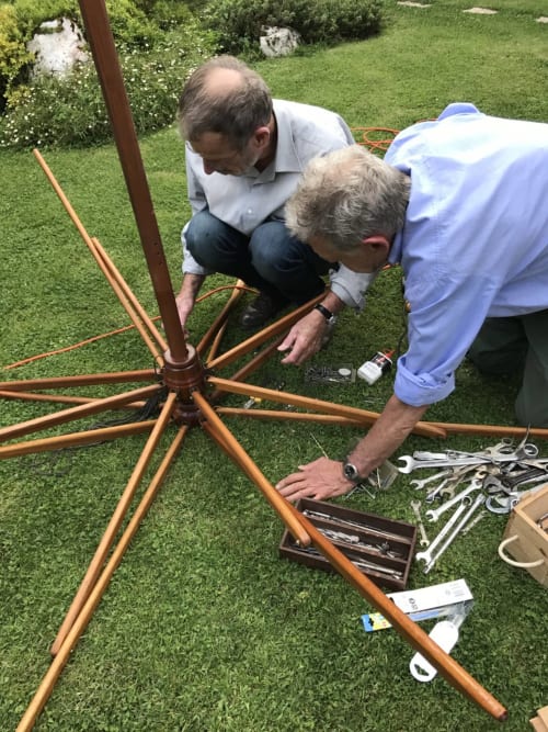 Two men assembling wooden garden structure at Manoir De Rieuzal, a French countryside bed and breakfast in Loubressac