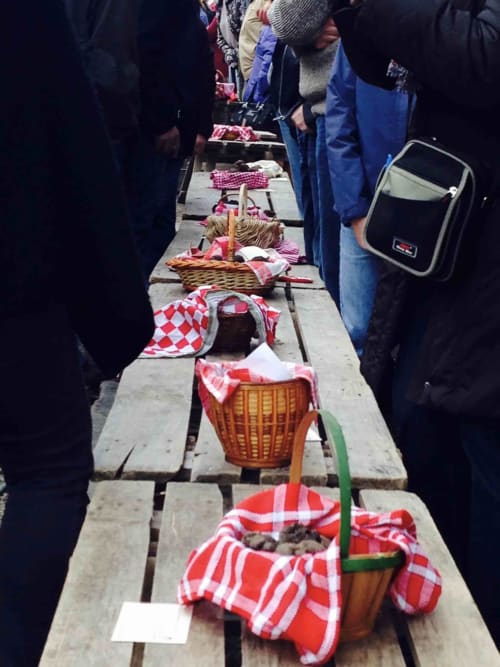 Outdoor picnic spread at Manoir De Rieuzal with baskets and red checkered cloths on wooden table