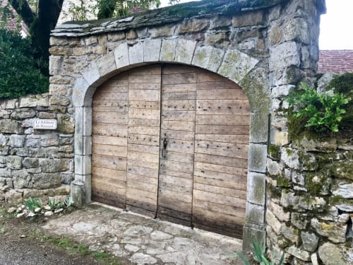 Arched wooden gate entrance at Manoir de Rieuzal, a charming stone B&B in Loubressac, France