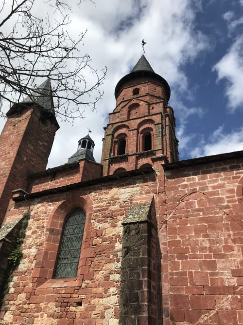 Historic red brick church tower with cross at Manoir De Rieuzal in Loubressac, France