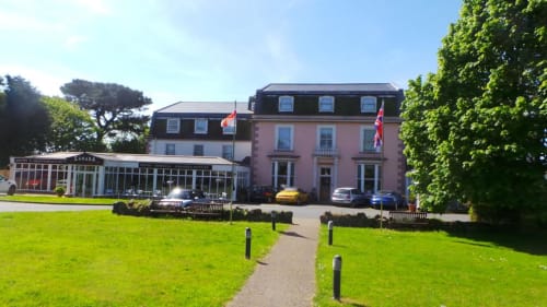L'hôtel La Trelade à St Martins, bâtiment victorien rose, jardins soignés et murs couverts de lierre
