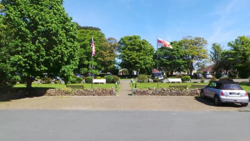 Entrée de l'hôtel La Trelade à St Martins avec allée bordée d'arbres, drapeaux et voiture garée par beau temps