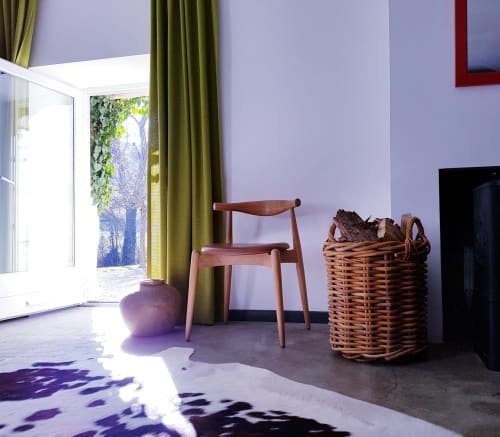 Zonnig zithoekje in de Saint André kamer van Moulin Renaudiots, Autun, met houten stoel en rieten mand