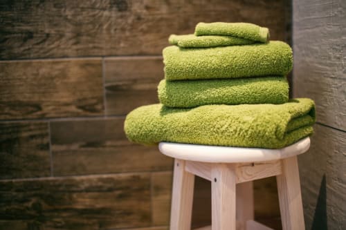 Pile de serviettes vert citron sur un tabouret en bois à l'hôtel La Trelade, St Martins