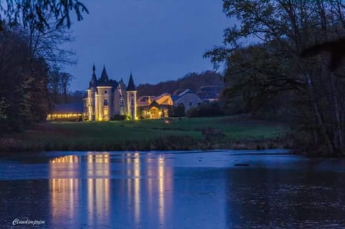 Burg Hassonville in der Dämmerung erleuchtet, gespiegelt im Fluss, Marche-en-Famenne Belgien