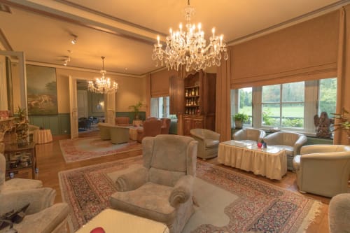Elegant lounge at Château d'Hassonville B&B in Marche-en-Famenne with crystal chandeliers and classic furnishings