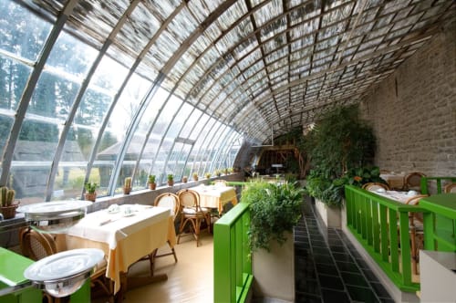 Glazen eetzaal van Château d'Hassonville B&B in Marche-en-Famenne, België, met planten en elegant diner