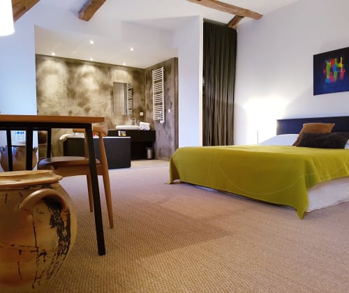 St Andoche kamer in hotel Moulin Renaudiots in Autun met limoengroen dekbed, zithoek en stenen badkamer