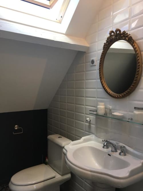 Modern bathroom in Annex King Room at Le château d'Hermonville, featuring pedestal sink, ornate mirror, and subway tile walls