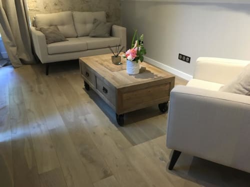 Modern living room in Annex King Room at Le château d'Hermonville with cream sofas, wooden coffee table, and light wood