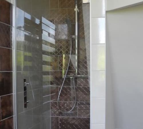 Modern shower enclosure with dark marble tiles at Le château d'Hermonville luxury B&B in Hermonville, France
