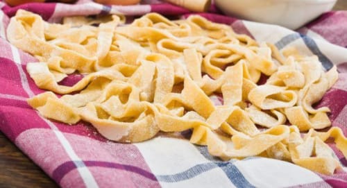 Nastri di pasta fresca su tessuto a scacchi presso la B&B I Coppi, San Gimignano